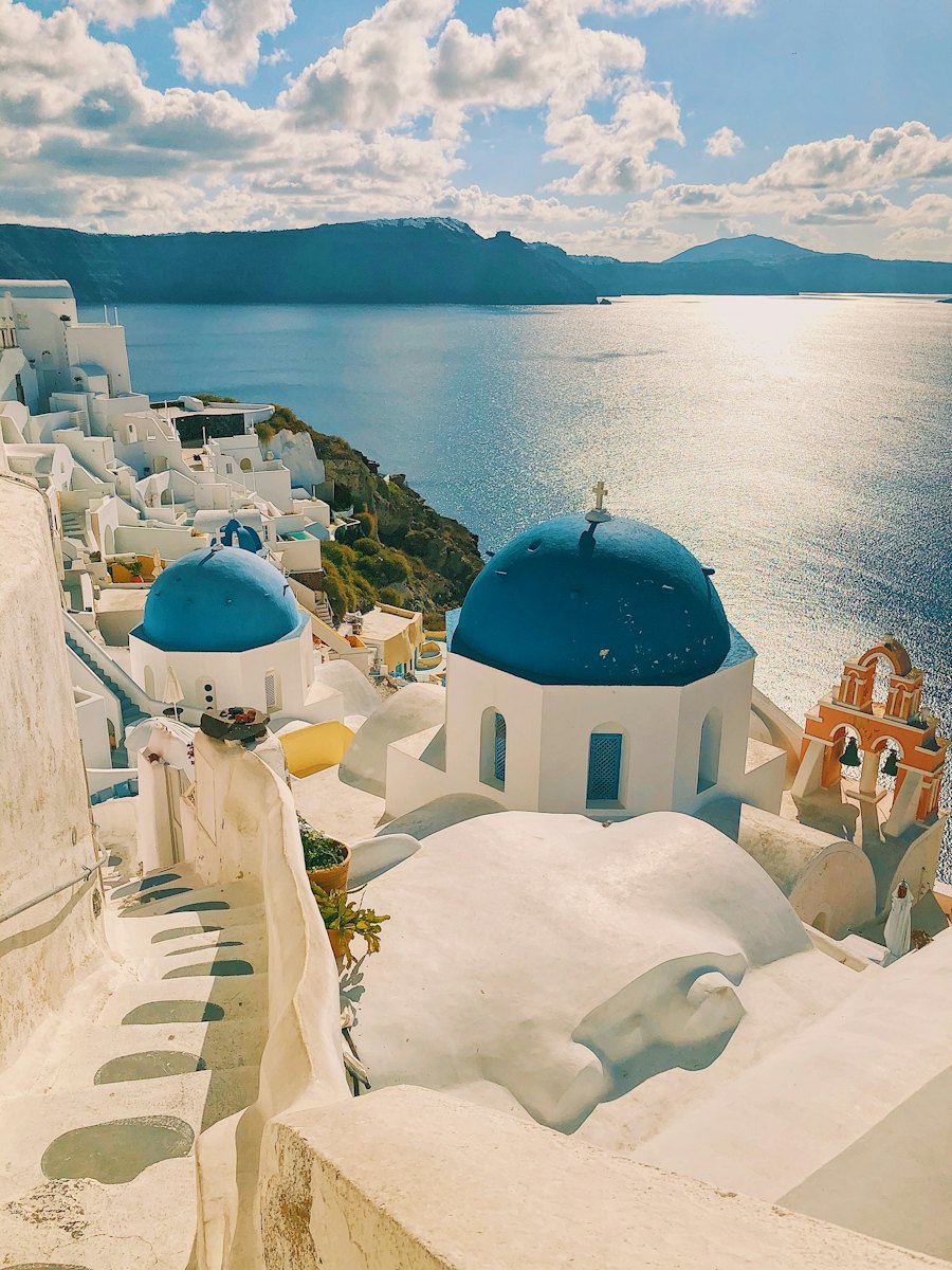 White houses and blue domes on a Greek island above a turquoise sea